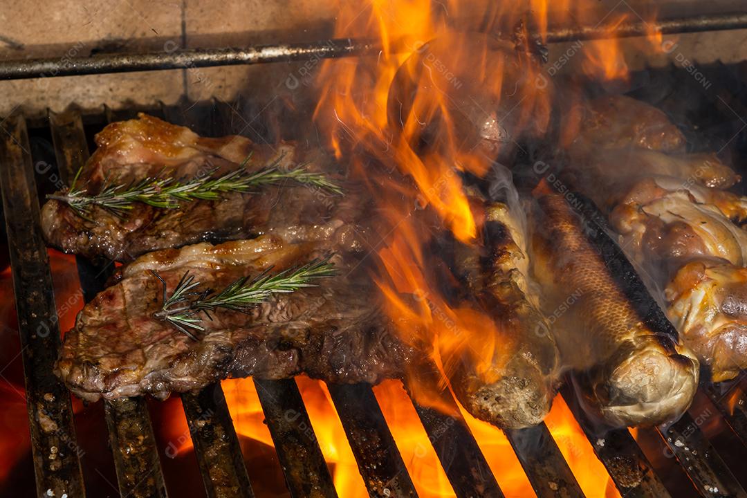 desastre. fogo na churrasqueira com carne, pão de alho e frango