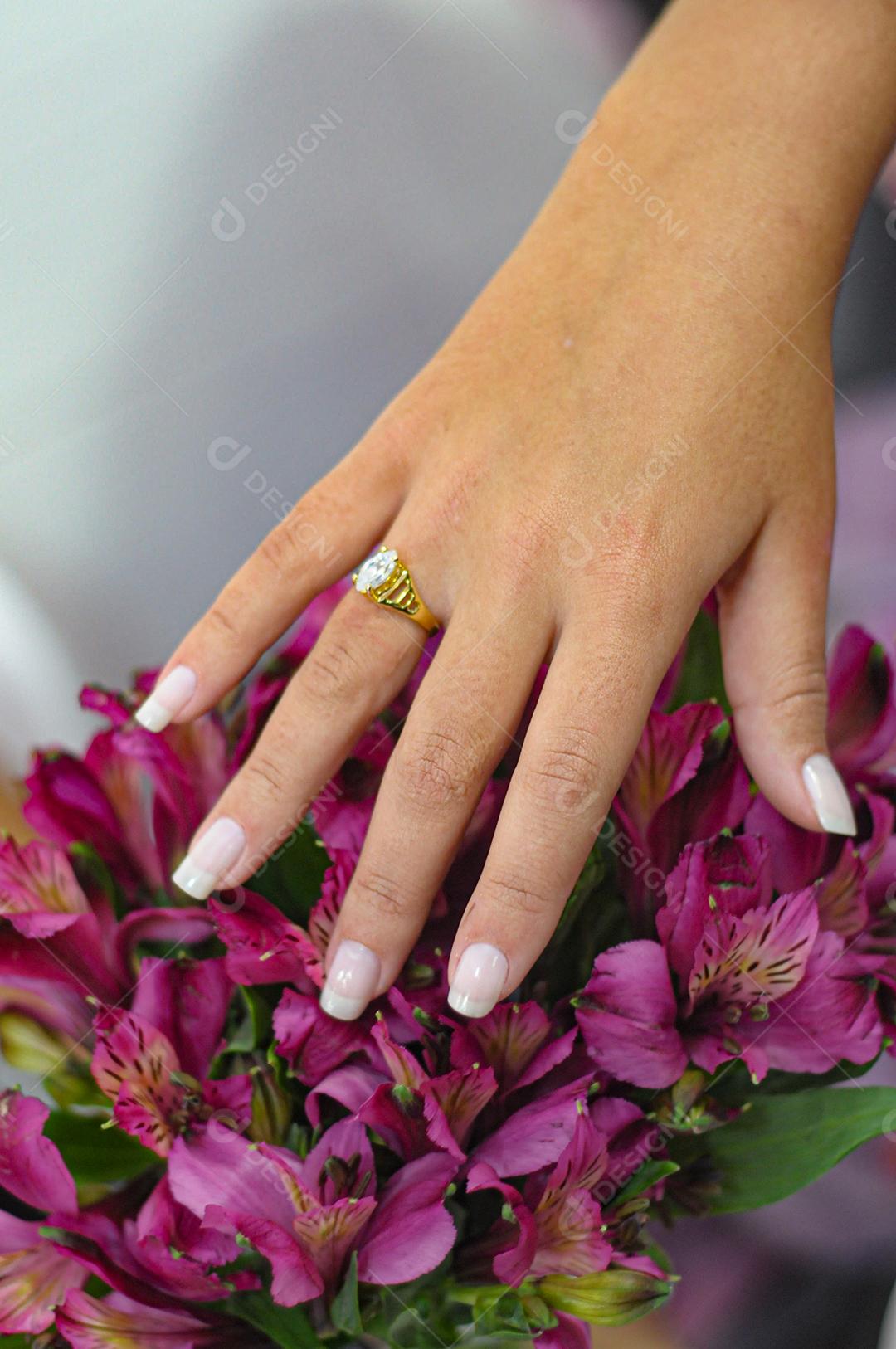 Fêmea entrega um buquê de flores roxas.