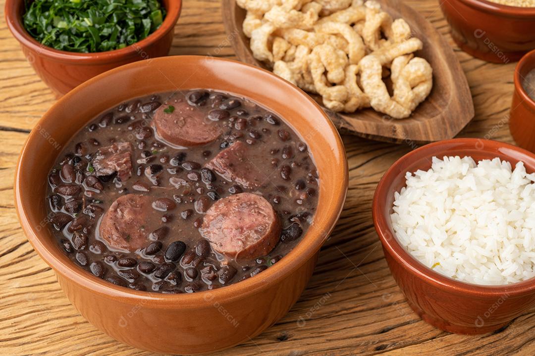 Acompanhamentos típicos da feijoada brasileira. Arroz, couve, pimenta, farofa e torresmo.