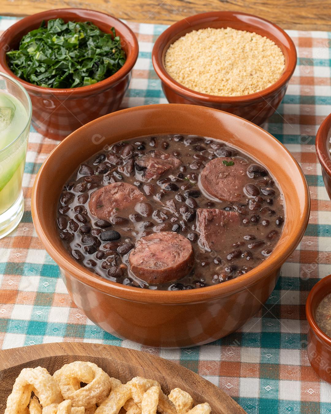 Acompanhamentos típicos da feijoada brasileira. Arroz, couve, pimenta, farofa e torresmo.