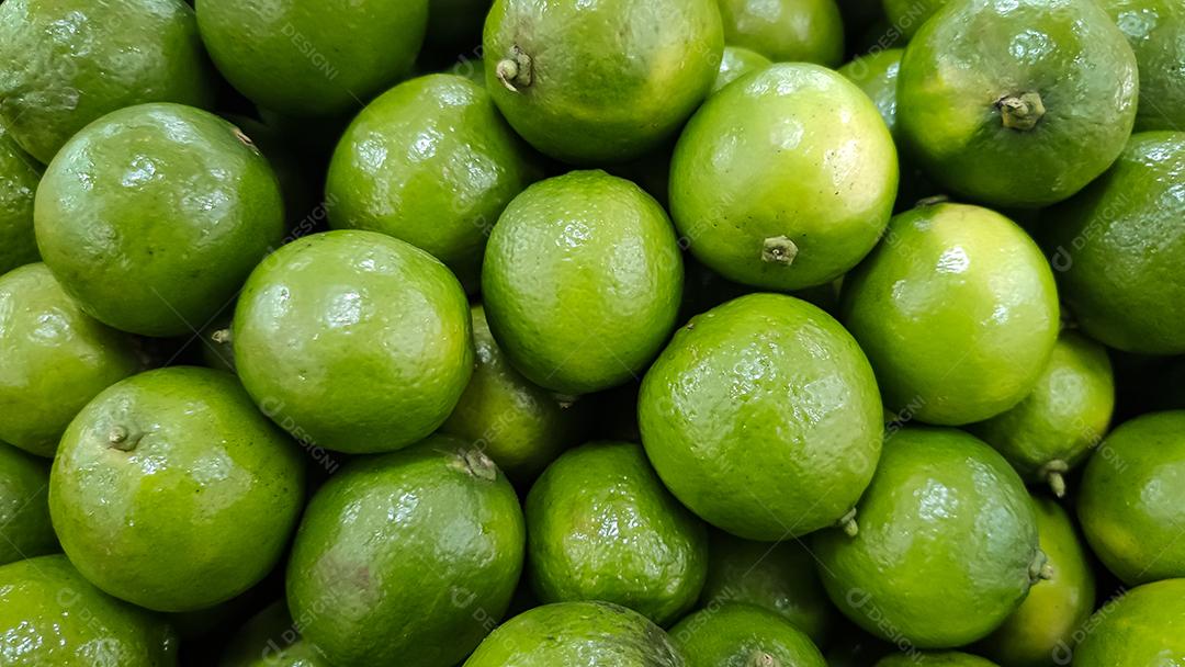 muitos limões verdes dentro de uma cesta. agrupados em grande número. fundo na vista superior