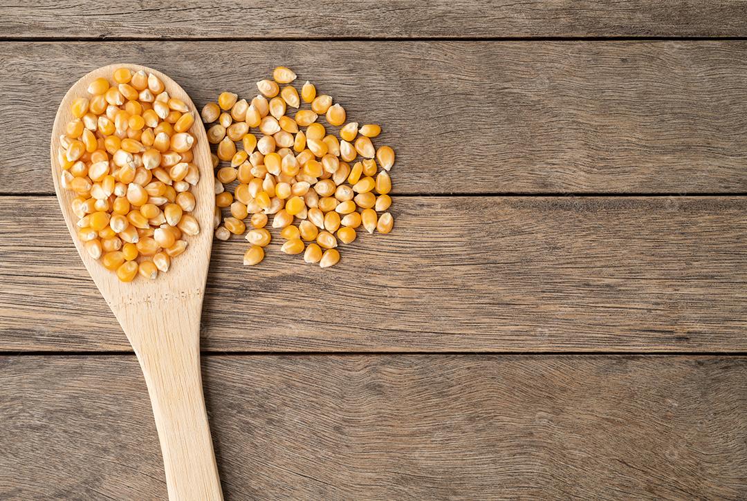 Grão de milho em uma colher mesa de madeira com espaço de cópia.