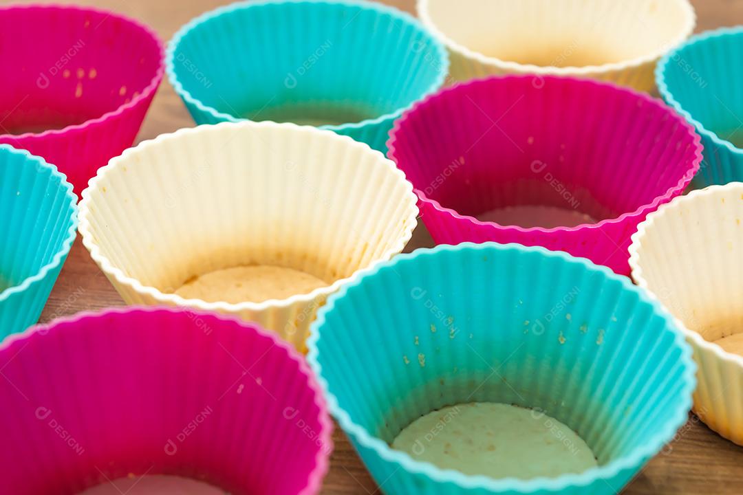 grupo de moldes de silicone coloridos para cupcake, nas cores branco, roxo e azul