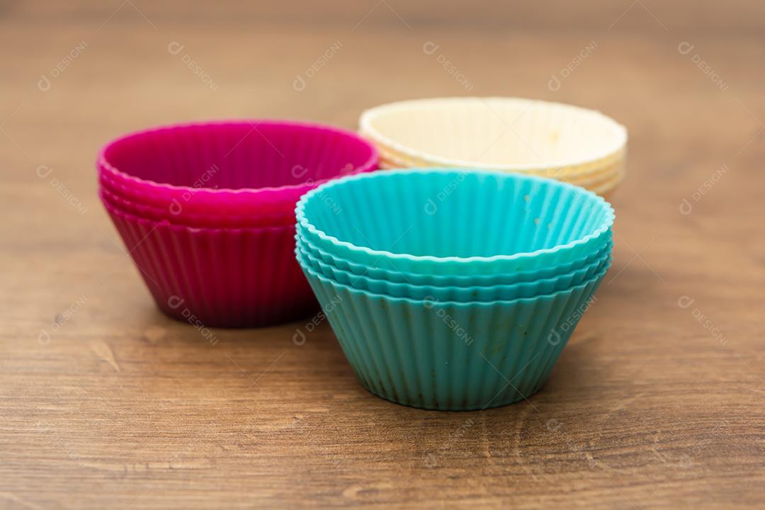 grupo de moldes de silicone coloridos para cupcake, nas cores branco, roxo e azul