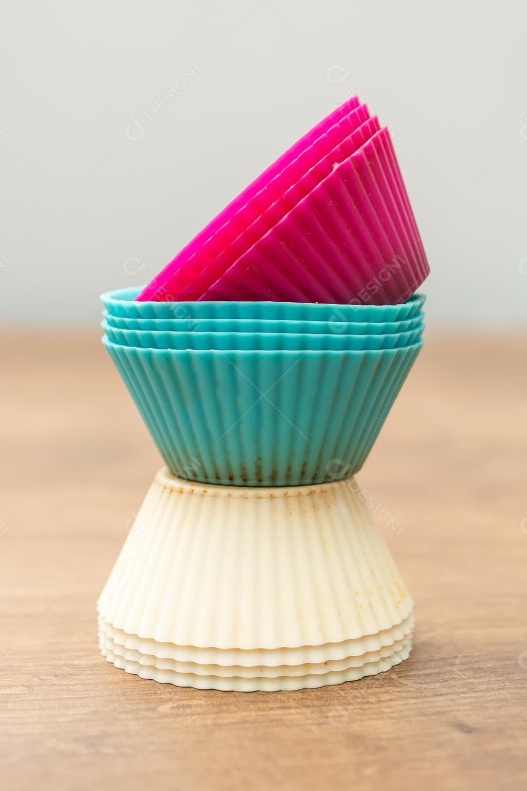 grupo de moldes de silicone coloridos para cupcake, nas cores branco, roxo e azul