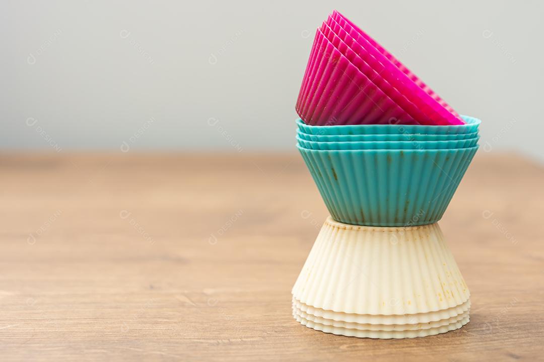 grupo de moldes de silicone coloridos para cupcake, nas cores branco, roxo e azul
