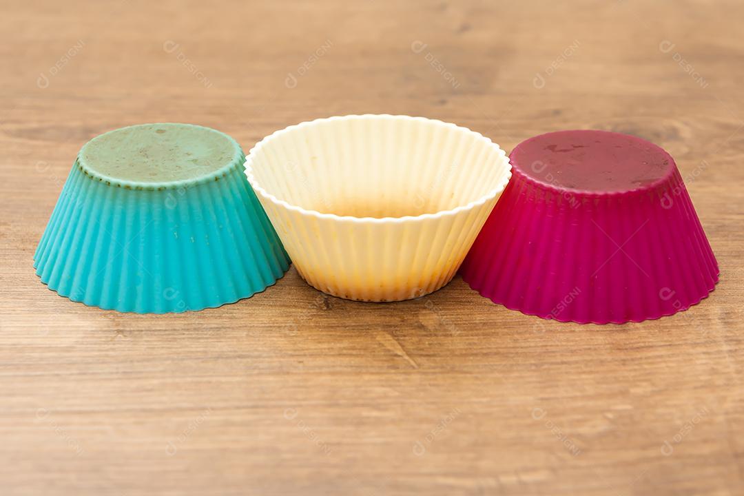 grupo de moldes de silicone coloridos para cupcake, nas cores branco, roxo e azul