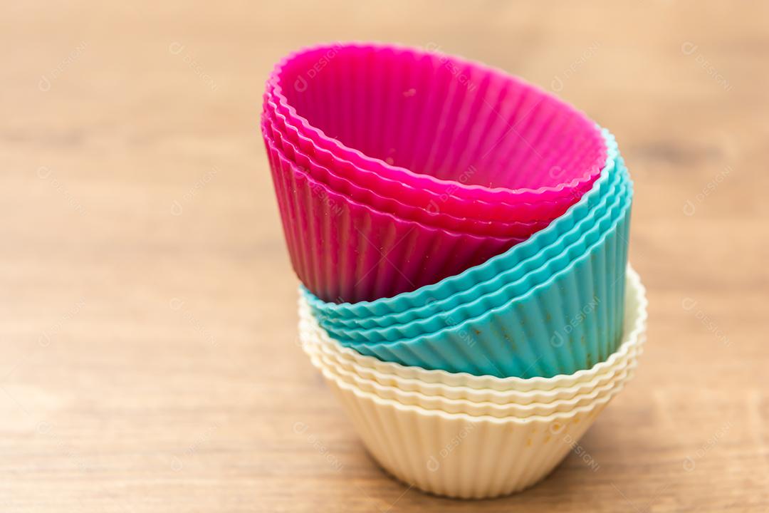 grupo de moldes de silicone coloridos para cupcake, nas cores branco, roxo e azul