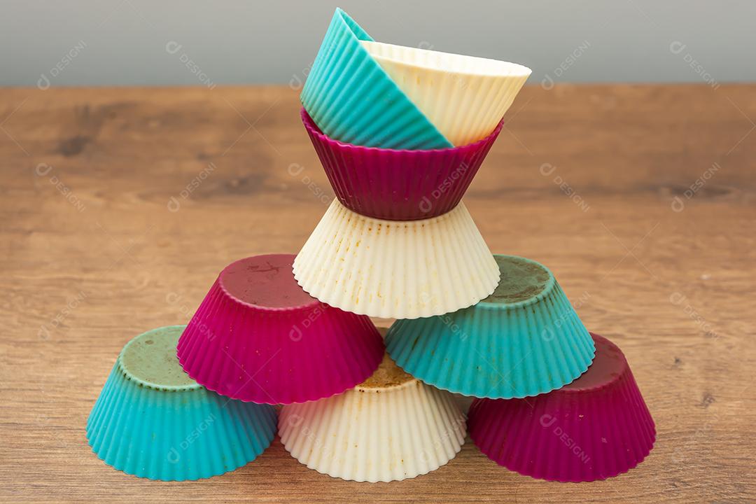 grupo de moldes de silicone coloridos para cupcake, nas cores branco, roxo e azul