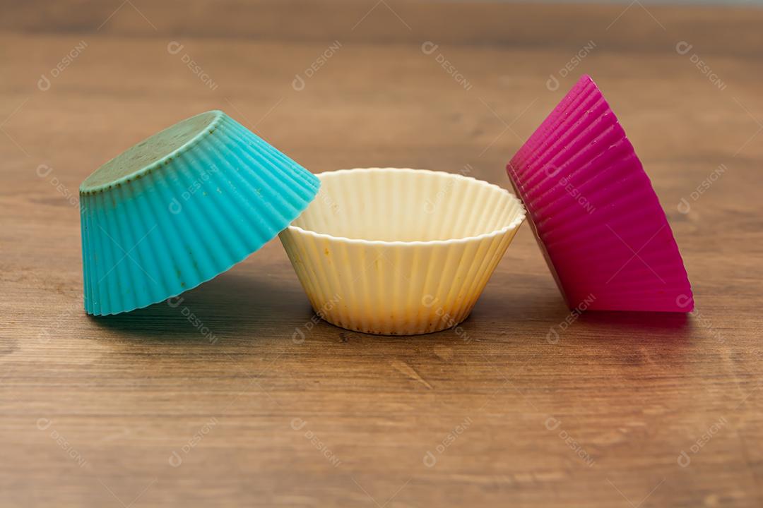 grupo de moldes de silicone coloridos para cupcake, nas cores branco, roxo e azul