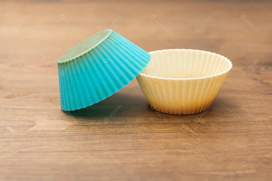 grupo de moldes de silicone coloridos para cupcake, nas cores branco, roxo e azul