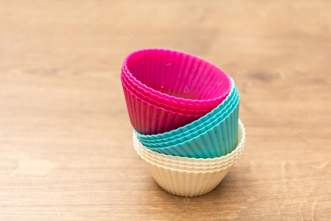 grupo de moldes de silicone coloridos para cupcake, nas cores branco, roxo e azul