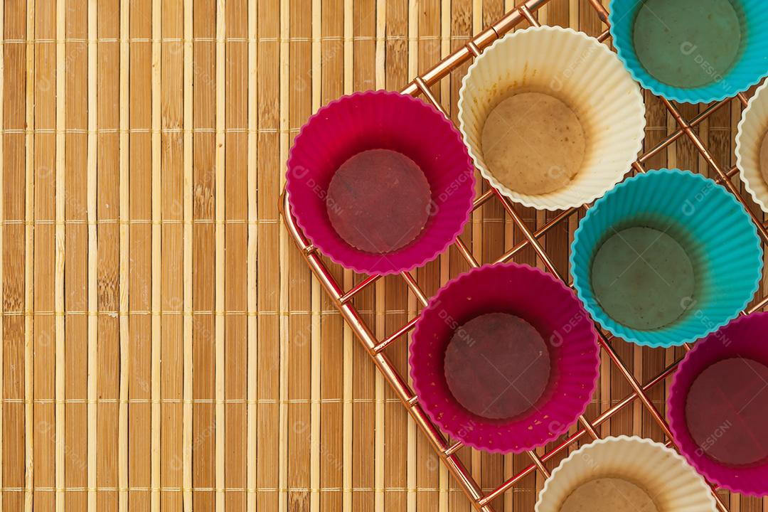 grupo de moldes de silicone coloridos para cupcake, nas cores branco, roxo e azul