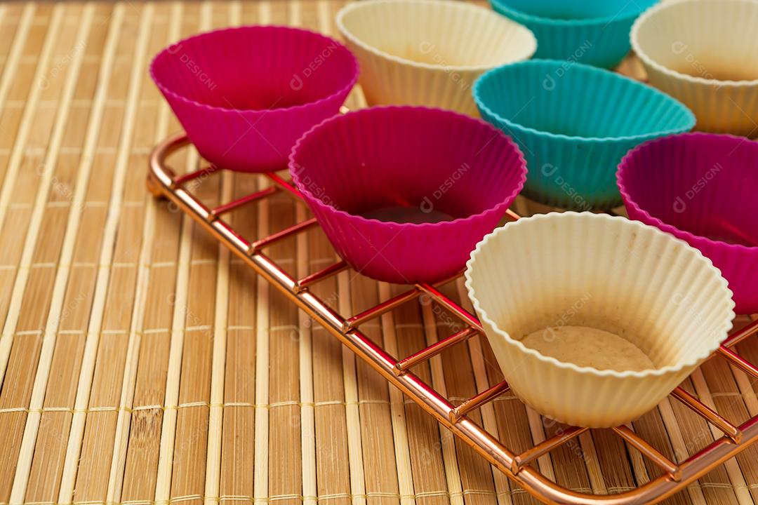 grupo de moldes de silicone coloridos para cupcake, nas cores branco, roxo e azul