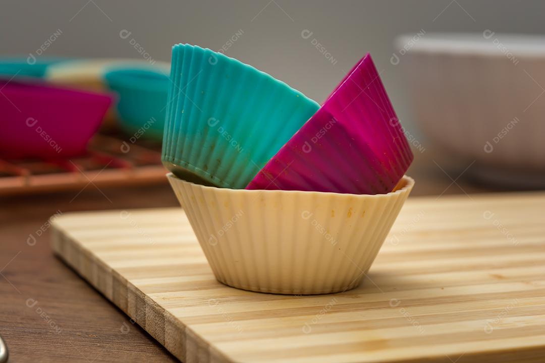 grupo de moldes de silicone coloridos para cupcake, nas cores branco, roxo e azul