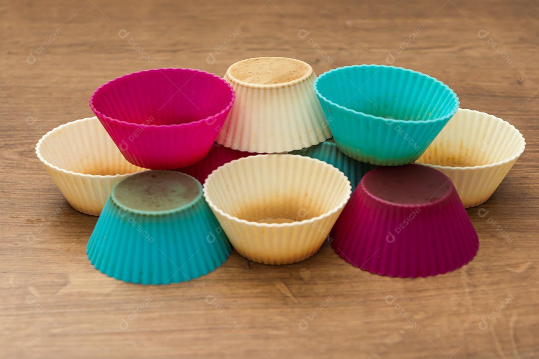 grupo de moldes de silicone coloridos para cupcake, nas cores branco, roxo e azul