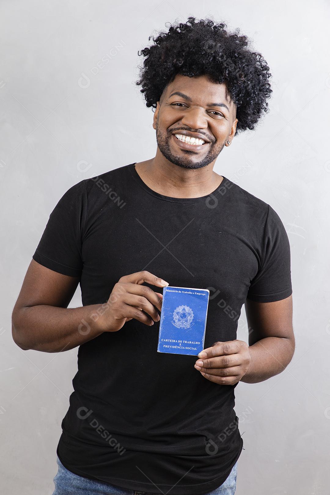 Jovem afro segurando o cartão de trabalho brasileiro