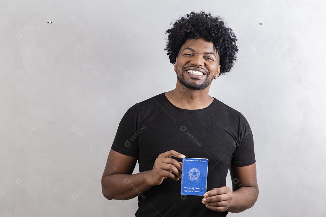 Jovem afro segurando o cartão de trabalho brasileiro