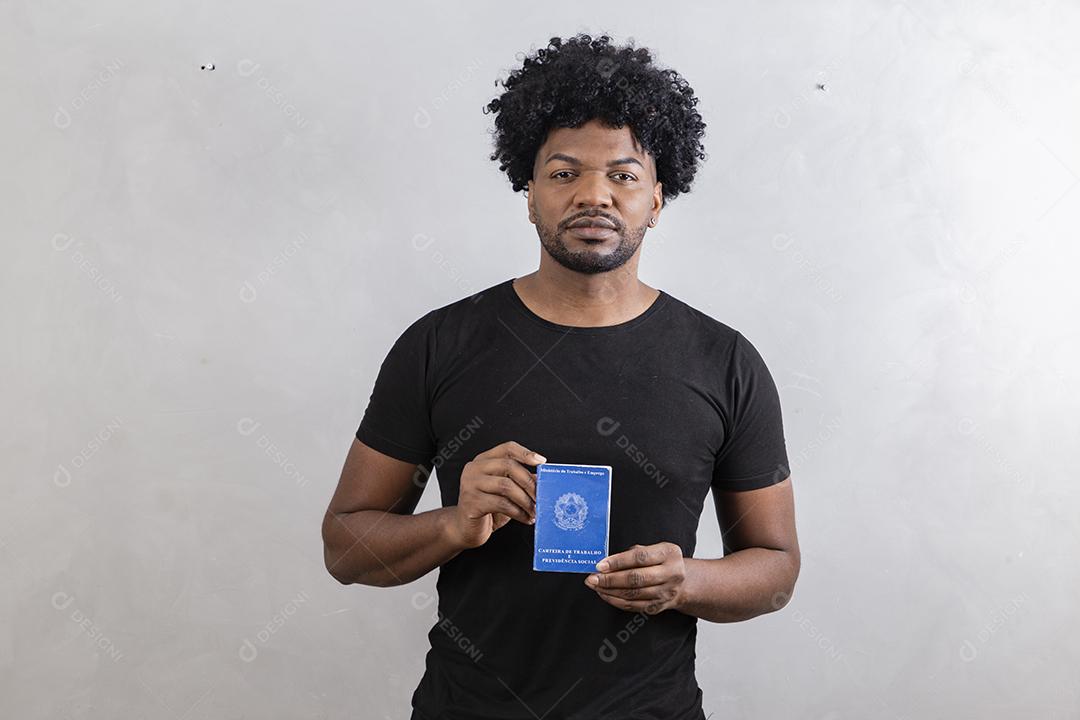 Jovem afro segurando o cartão de trabalho brasileiro