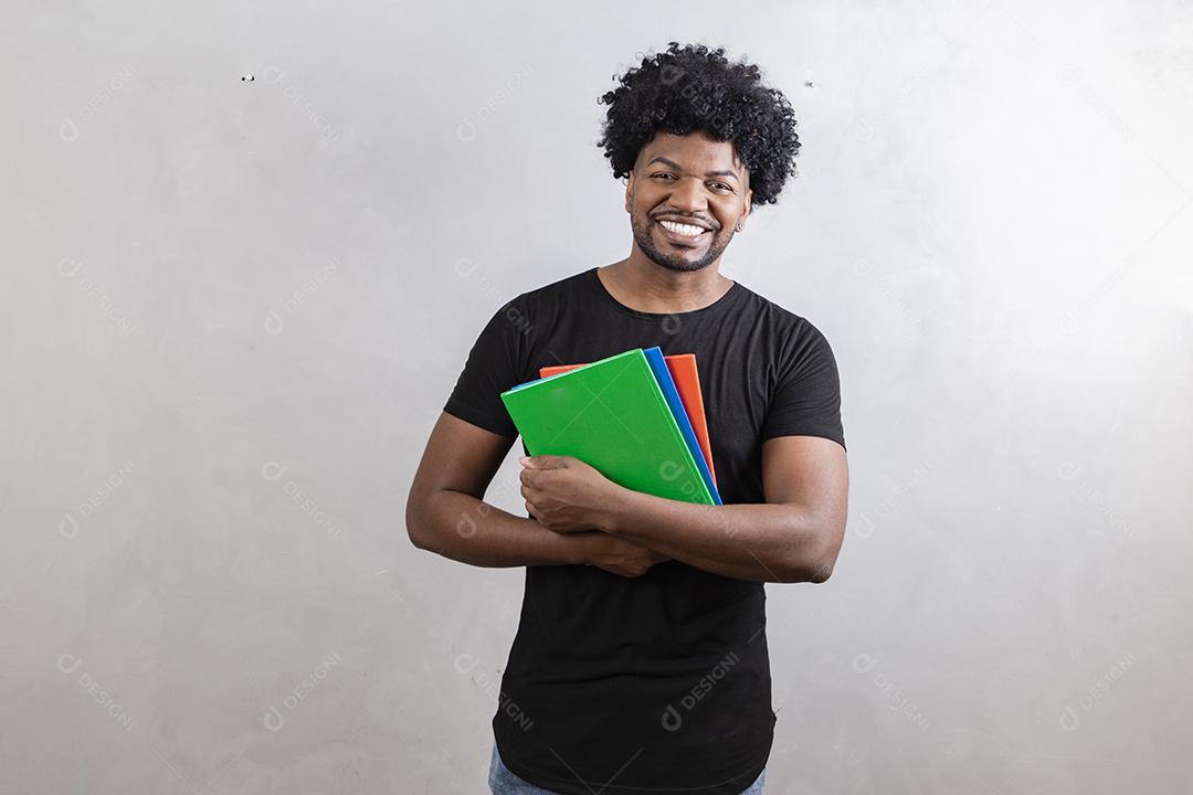 jovem estudante negro com livros e cadernos no fundo