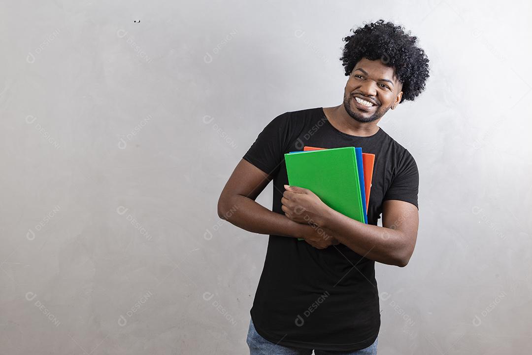 jovem estudante negro com livros e cadernos no fundo