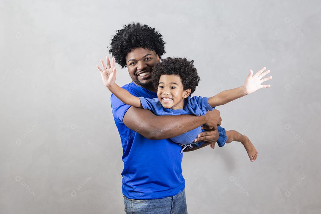 Pai segurando seu filho em fundo cinza