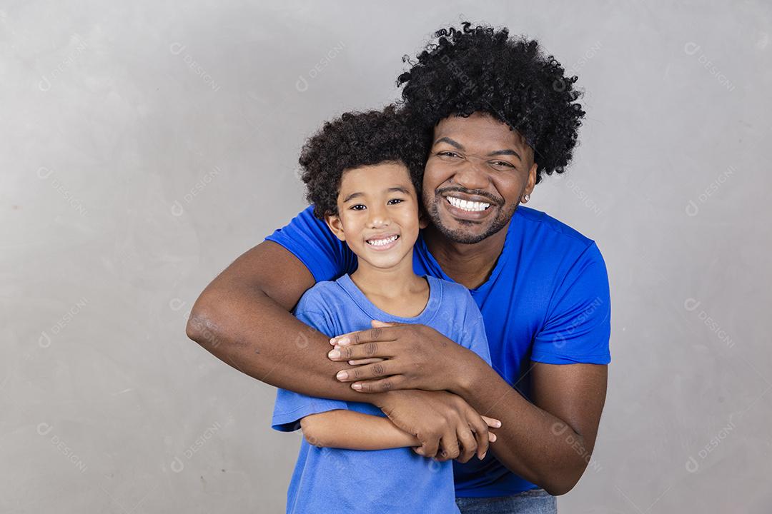 Pai segurando seu filho em fundo cinza