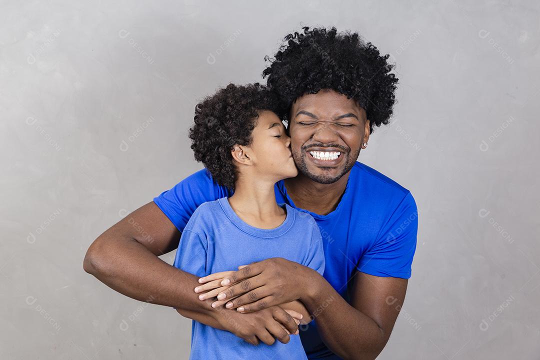 Afro pai e filho negro sobre fundo cinza sorrindo e feliz. papai afro no dia dos pais. dia dos pais em agosto