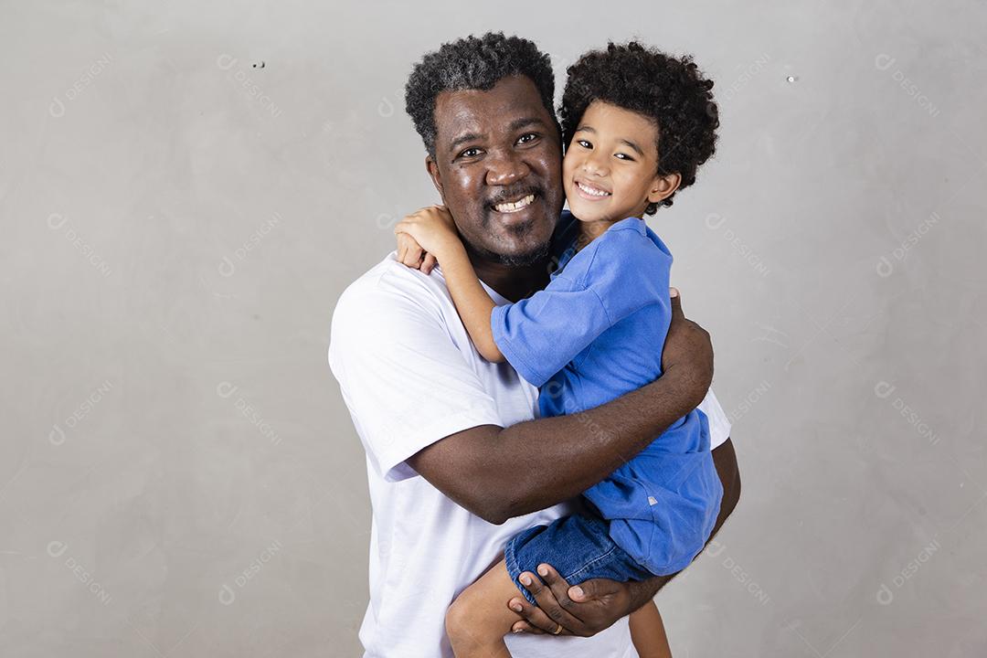 Afro pai e filho negro sobre fundo cinza sorrindo e feliz. papai afro no dia dos pais. dia dos pais em agosto