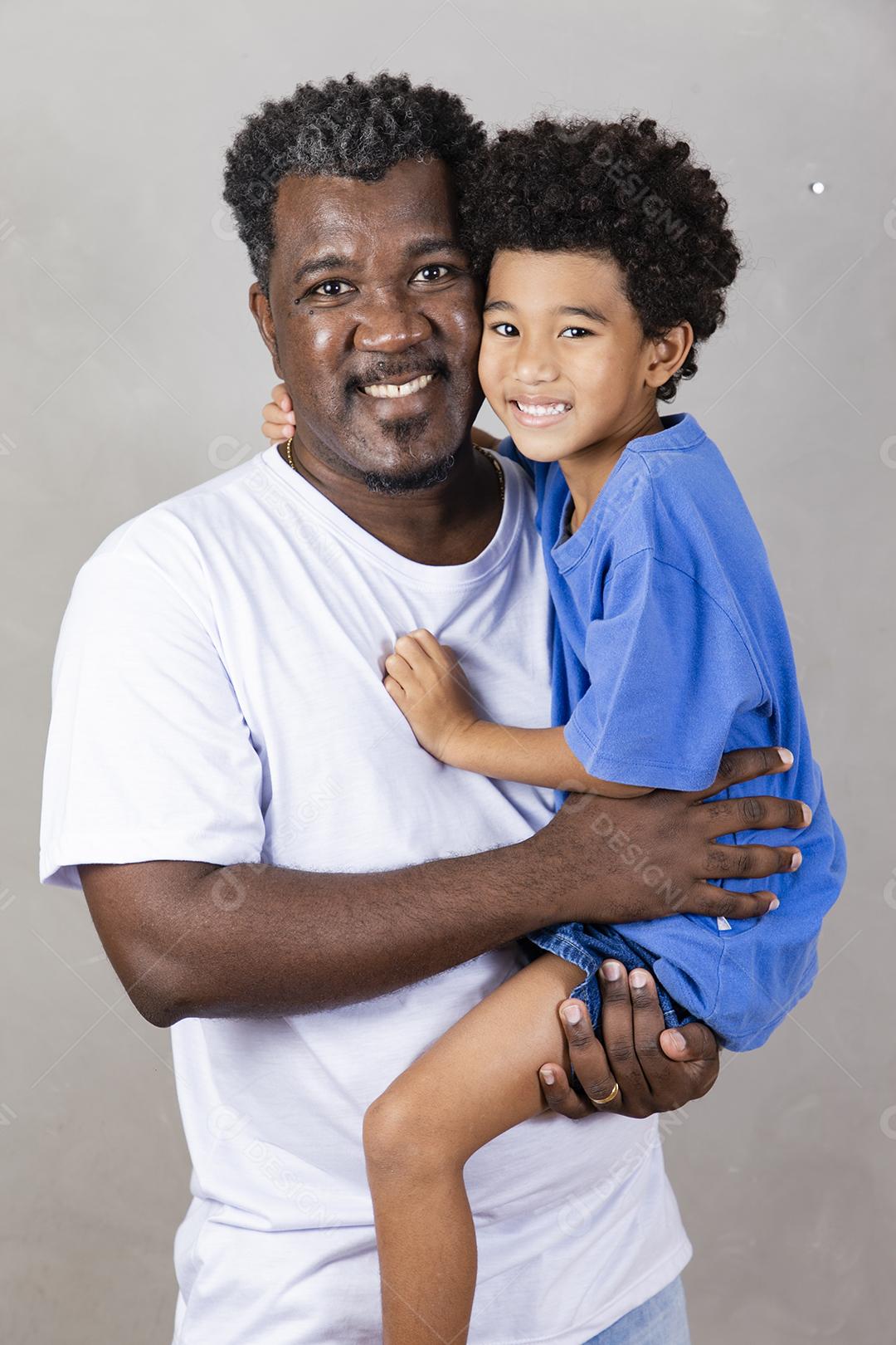 Afro pai e filho negro sobre fundo cinza sorrindo e feliz. papai afro no dia dos pais. dia dos pais em agosto