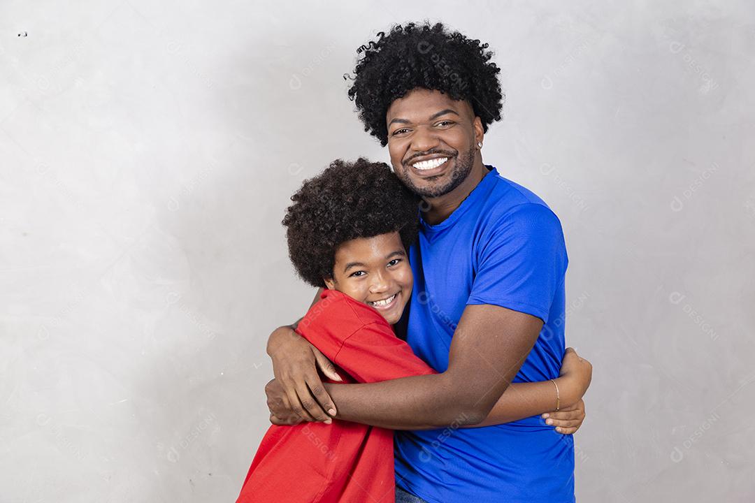 Afro pai e filho negro sobre fundo cinza sorrindo e feliz. papai afro no dia dos pais. dia dos pais em agosto