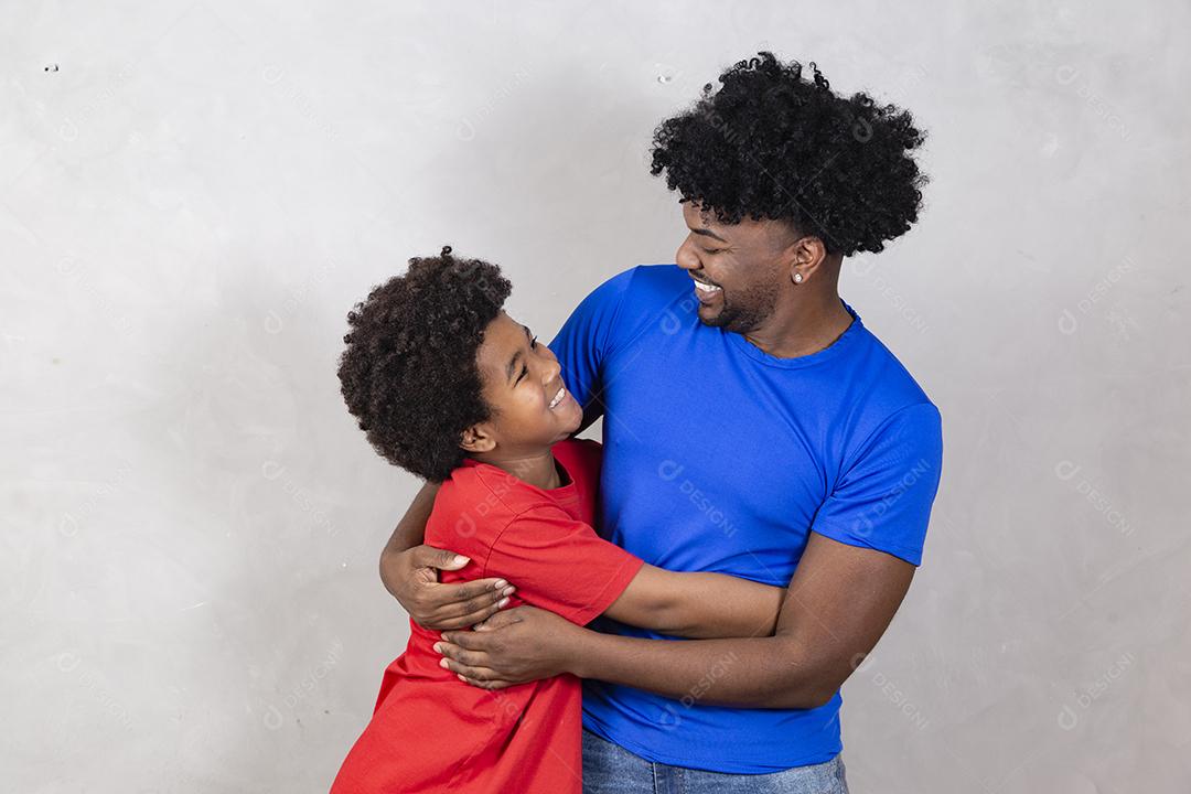 Afro pai e filho negro sobre fundo cinza sorrindo e feliz. papai afro no dia dos pais. dia dos pais em agosto