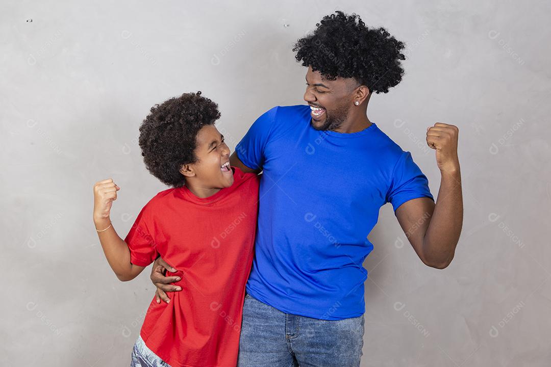 Afro pai e filho negro sobre fundo cinza sorrindo e feliz. papai afro no dia dos pais. dia dos pais em agosto