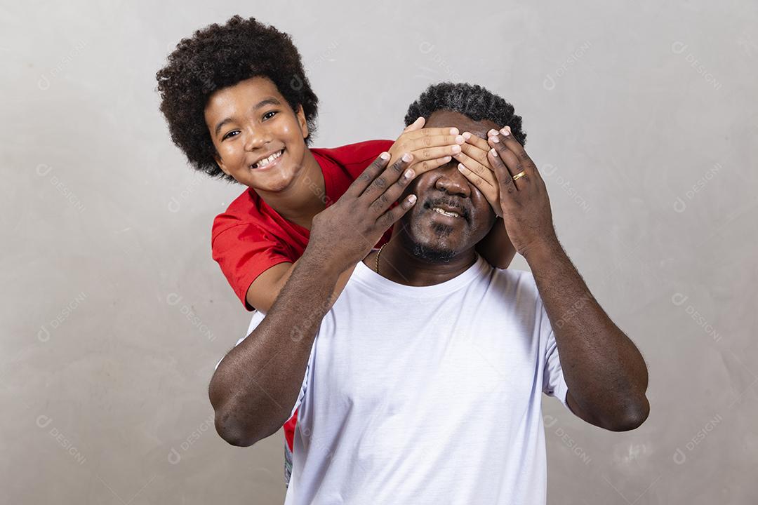 Afro pai e filho negro sobre fundo cinza sorrindo e feliz. papai afro no dia dos pais. dia dos pais em agosto
