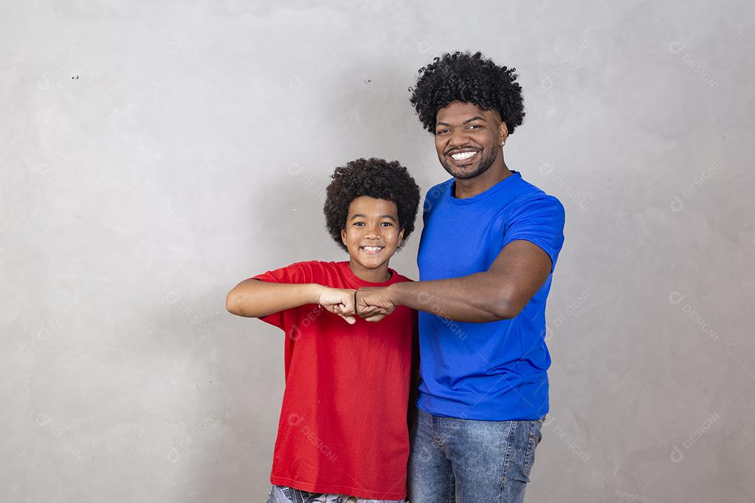 Afro pai e filho comemorando em fundo cinza feliz pelo dia dos pais ou dia das crianças