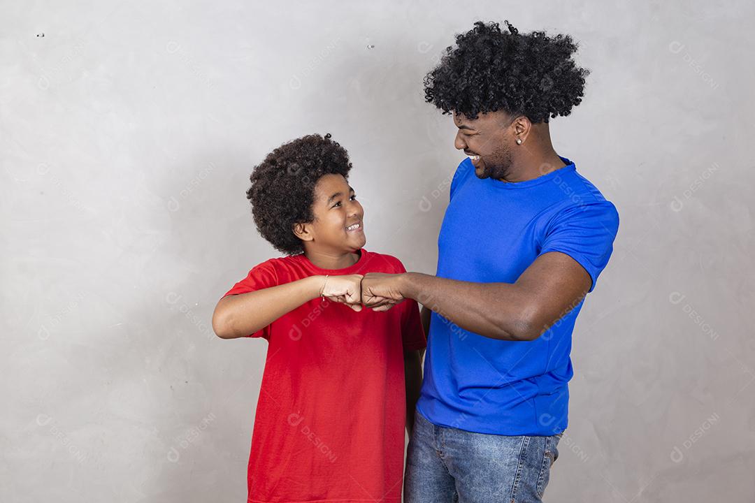 Afro pai e filho comemorando em fundo cinza feliz pelo dia dos pais ou dia das crianças