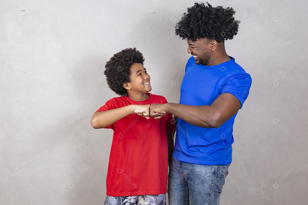 Afro pai e filho comemorando em fundo cinza feliz pelo dia dos pais ou dia das crianças
