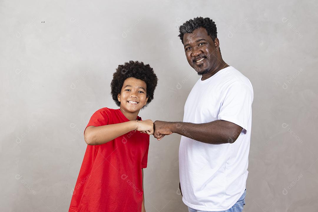 Afro pai e filho comemorando em fundo cinza feliz pelo dia dos pais ou dia das crianças