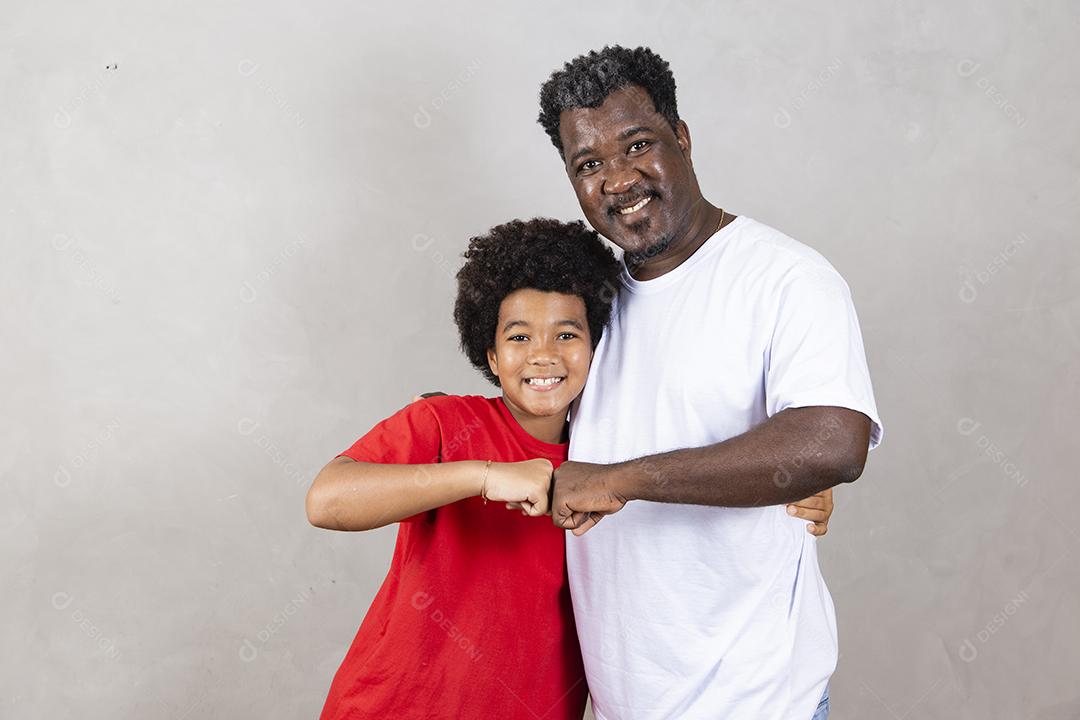 Afro pai e filho comemorando em fundo cinza feliz pelo dia dos pais ou dia das crianças