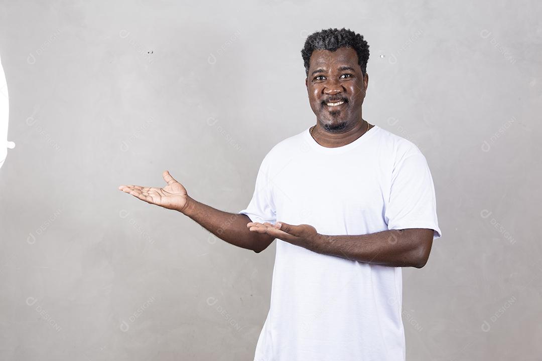 Retrato de um homem afro feliz sorrindo com os braços cruzados em pé contra o fundo branco