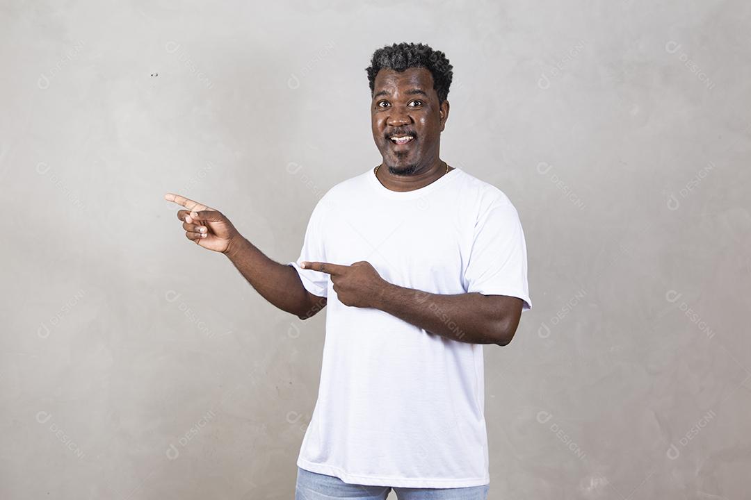 Retrato de um homem afro feliz sorrindo com os braços cruzados em pé contra o fundo branco