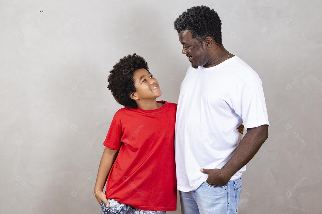 afro pai e filho em fundo neutro Dia dos Pais