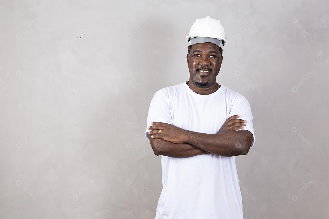 Homem arquiteto afro usando capacete de construtor sobre fundo isolado com sorriso legal feliz no rosto