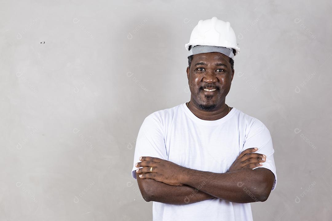 Homem arquiteto afro usando capacete de construtor sobre fundo isolado com sorriso legal feliz no rosto