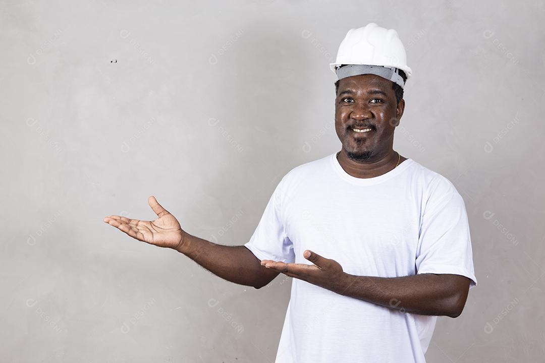 Homem arquiteto afro usando capacete de construtor sobre fundo isolado com sorriso legal feliz no rosto