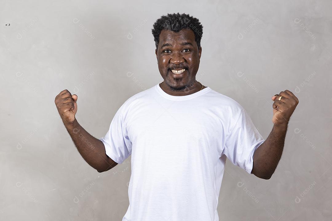 Homem afro emocional gritando punhos trêmulos sobre o fundo cinza do estúdio olhando para a câmera