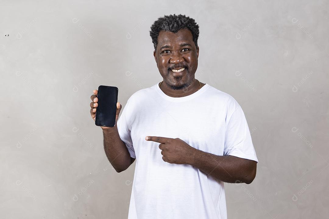 Publicidade em aplicativos móveis. Animado homem afro bonito mostrando apontando para a tela branca vazia do smartphone
