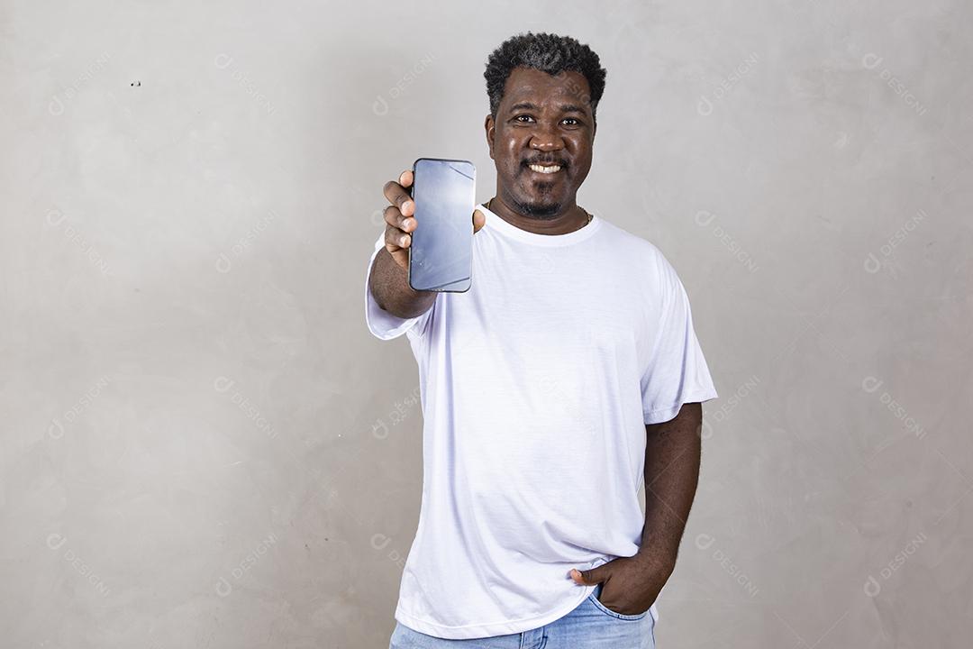Publicidade em aplicativos móveis. Animado homem afro bonito mostrando apontando para a tela branca vazia do smartphone