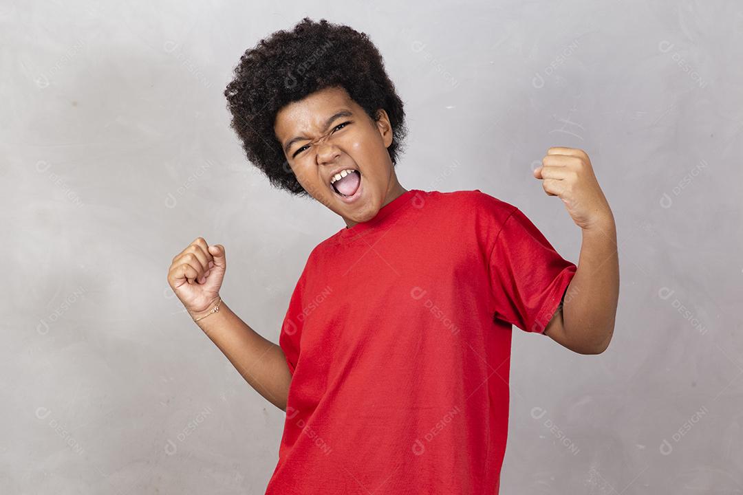 Garoto afro com cabelo preto em fundo cinza. Menino afro sorridente com cabelo preto. Menino com um cabelo black power.