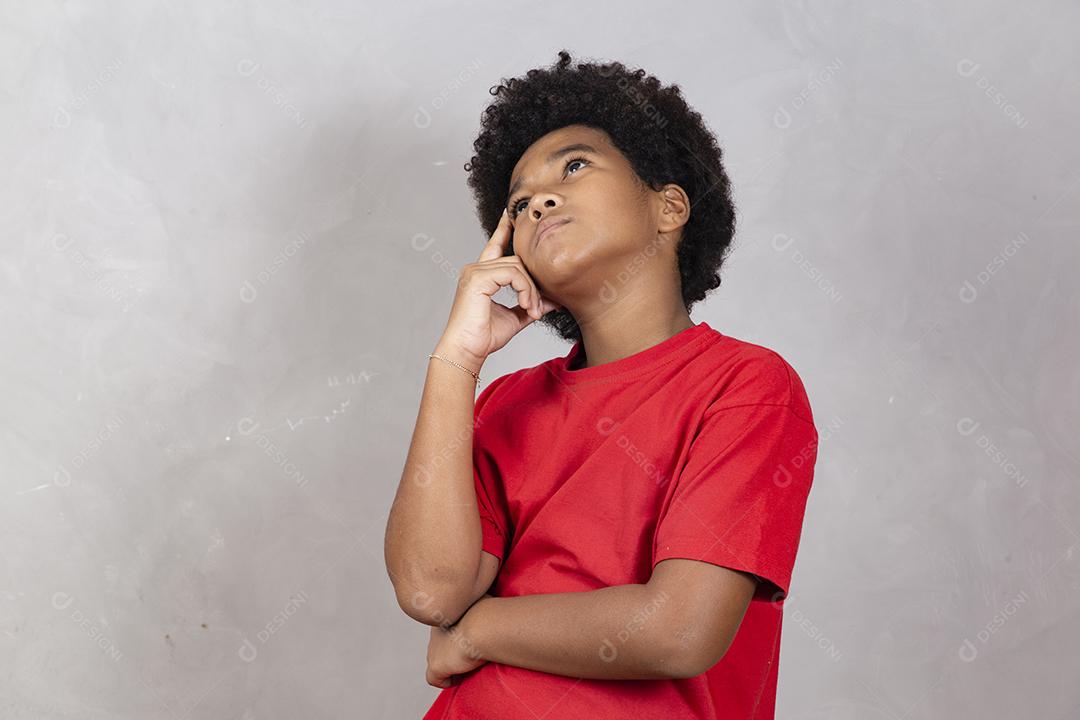 adorável menino africano pensando em fundo cinza